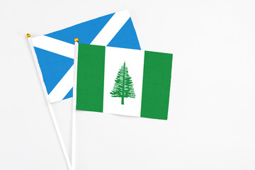 Norfolk Island and Scotland stick flags on white background. High quality fabric, miniature national flag. Peaceful global concept.White floor for copy space.