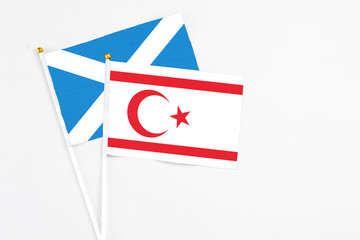Northern Cyprus and Scotland stick flags on white background. High quality fabric, miniature national flag. Peaceful global concept.White floor for copy space.