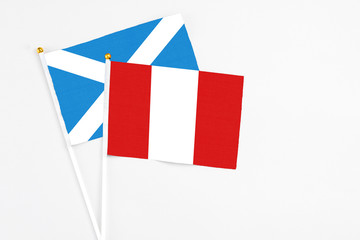 Peru and Scotland stick flags on white background. High quality fabric, miniature national flag. Peaceful global concept.White floor for copy space.