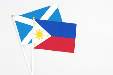Philippines and Scotland stick flags on white background. High quality fabric, miniature national flag. Peaceful global concept.White floor for copy space.