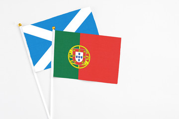 Portugal and Scotland stick flags on white background. High quality fabric, miniature national flag. Peaceful global concept.White floor for copy space.