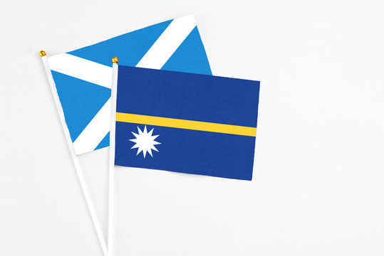 Nauru and Scotland stick flags on white background. High quality fabric, miniature national flag. Peaceful global concept.White floor for copy space.