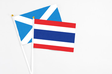 Thailand and Scotland stick flags on white background. High quality fabric, miniature national flag. Peaceful global concept.White floor for copy space.