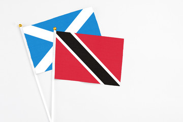 Trinidad And Tobago and Scotland stick flags on white background. High quality fabric, miniature national flag. Peaceful global concept.White floor for copy space.