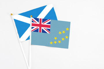 Tuvalu and Scotland stick flags on white background. High quality fabric, miniature national flag. Peaceful global concept.White floor for copy space.