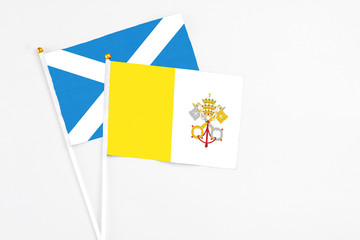 Vatican City and Scotland stick flags on white background. High quality fabric, miniature national flag. Peaceful global concept.White floor for copy space.