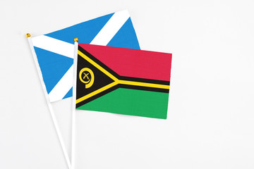 Vanuatu and Scotland stick flags on white background. High quality fabric, miniature national flag. Peaceful global concept.White floor for copy space.