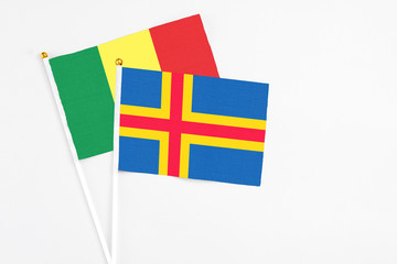 Aland Islands and Senegal stick flags on white background. High quality fabric, miniature national flag. Peaceful global concept.White floor for copy space.
