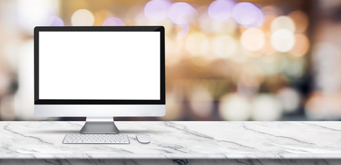 Blank screen desktop computer on marble table top with blur bar restaurant bokeh background,Mock up for display or montage of design