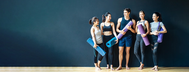 Group of diversity ethnic people holding Yoga mat talking together with smile. Asian girl laughing with funny face after finish training class. Happy and relax time in group of friend in Banner size.