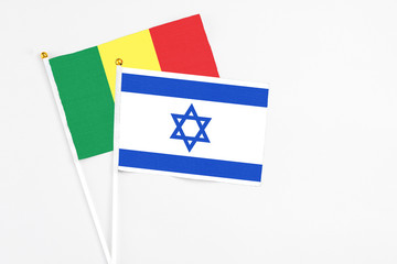 Israel and Senegal stick flags on white background. High quality fabric, miniature national flag. Peaceful global concept.White floor for copy space.