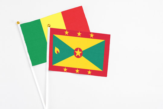 Grenada and Senegal stick flags on white background. High quality fabric, miniature national flag. Peaceful global concept.White floor for copy space.
