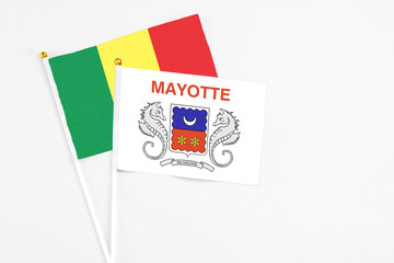 Mayotte and Senegal stick flags on white background. High quality fabric, miniature national flag. Peaceful global concept.White floor for copy space.