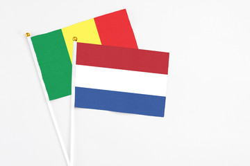 Netherlands and Senegal stick flags on white background. High quality fabric, miniature national flag. Peaceful global concept.White floor for copy space.