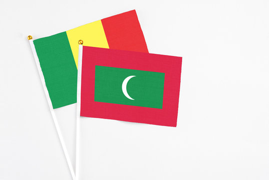 Maldives and Senegal stick flags on white background. High quality fabric, miniature national flag. Peaceful global concept.White floor for copy space.