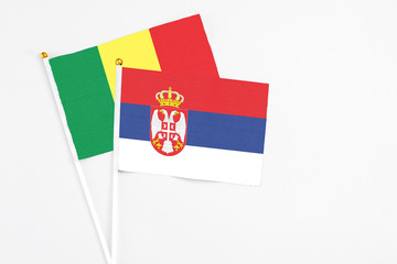 Serbia and Senegal stick flags on white background. High quality fabric, miniature national flag. Peaceful global concept.White floor for copy space.