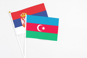 Azerbaijan and Serbia stick flags on white background. High quality fabric, miniature national flag. Peaceful global concept.White floor for copy space.