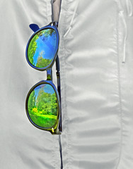 Sunglasses hang on zipper  of windbreaker