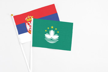 Macao and Serbia stick flags on white background. High quality fabric, miniature national flag. Peaceful global concept.White floor for copy space.
