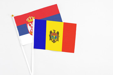Moldova and Serbia stick flags on white background. High quality fabric, miniature national flag. Peaceful global concept.White floor for copy space.
