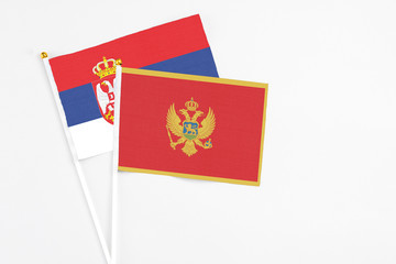 Montenegro and Serbia stick flags on white background. High quality fabric, miniature national flag. Peaceful global concept.White floor for copy space.
