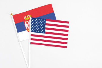 United States and Serbia stick flags on white background. High quality fabric, miniature national flag. Peaceful global concept.White floor for copy space.