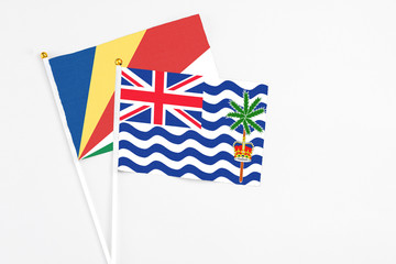 British Indian Ocean Territory and Seychelles stick flags on white background. High quality fabric, miniature national flag. Peaceful global concept.White floor for copy space.v