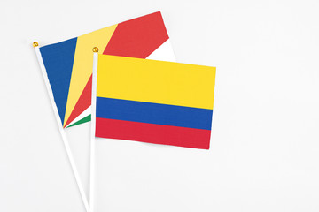 Colombia and Seychelles stick flags on white background. High quality fabric, miniature national flag. Peaceful global concept.White floor for copy space.v