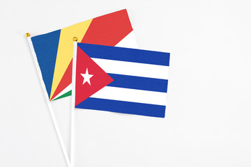 Cuba and Seychelles stick flags on white background. High quality fabric, miniature national flag. Peaceful global concept.White floor for copy space.v