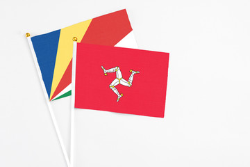 Isle Of Man and Seychelles stick flags on white background. High quality fabric, miniature national flag. Peaceful global concept.White floor for copy space.v