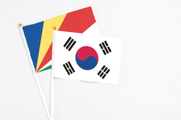 South Korea and Seychelles stick flags on white background. High quality fabric, miniature national flag. Peaceful global concept.White floor for copy space.v