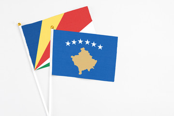 Kosovo and Seychelles stick flags on white background. High quality fabric, miniature national flag. Peaceful global concept.White floor for copy space.v