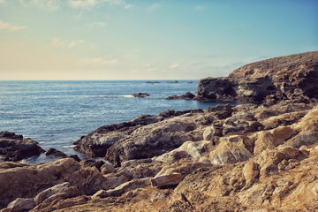 Fototapeta na wymiar Large rocks on a wild pacific ocean coastline