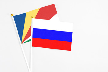 Russia and Seychelles stick flags on white background. High quality fabric, miniature national flag. Peaceful global concept.White floor for copy space.v