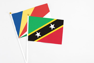 Saint Kitts And Nevis and Seychelles stick flags on white background. High quality fabric, miniature national flag. Peaceful global concept.White floor for copy space.v