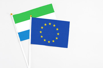 European Union and Sierra Leone stick flags on white background. High quality fabric, miniature national flag. Peaceful global concept.White floor for copy space.
