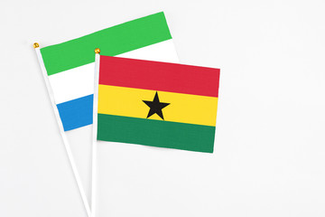 Ghana and Sierra Leone stick flags on white background. High quality fabric, miniature national flag. Peaceful global concept.White floor for copy space.