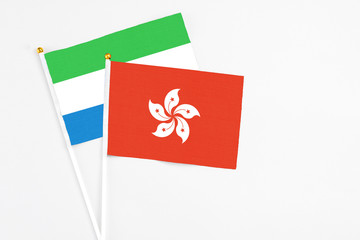 Hong Kong and Sierra Leone stick flags on white background. High quality fabric, miniature national flag. Peaceful global concept.White floor for copy space.