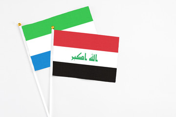 Iraq and Sierra Leone stick flags on white background. High quality fabric, miniature national flag. Peaceful global concept.White floor for copy space.