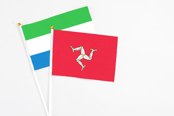 Isle Of Man and Sierra Leone stick flags on white background. High quality fabric, miniature national flag. Peaceful global concept.White floor for copy space.