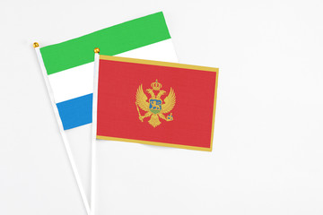 Montenegro and Sierra Leone stick flags on white background. High quality fabric, miniature national flag. Peaceful global concept.White floor for copy space.