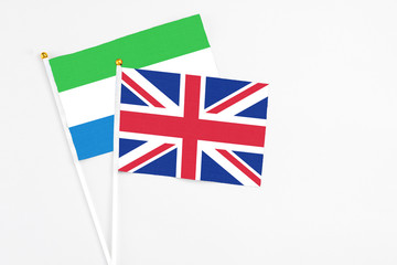 United Kingdom and Sierra Leone stick flags on white background. High quality fabric, miniature national flag. Peaceful global concept.White floor for copy space.