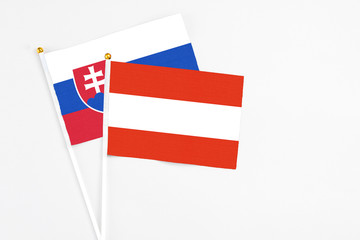 Austria and Slovakia stick flags on white background. High quality fabric, miniature national flag. Peaceful global concept.White floor for copy space.