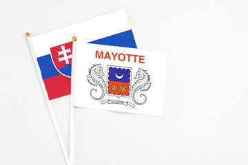 Mayotte and Slovakia stick flags on white background. High quality fabric, miniature national flag. Peaceful global concept.White floor for copy space.