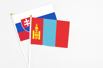 Fototapeta premium Mongolia and Slovakia stick flags on white background. High quality fabric, miniature national flag. Peaceful global concept.White floor for copy space.