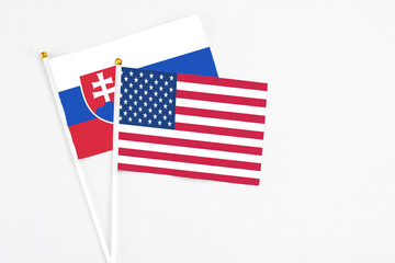 United States and Slovakia stick flags on white background. High quality fabric, miniature national flag. Peaceful global concept.White floor for copy space.