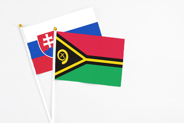 Vanuatu and Slovakia stick flags on white background. High quality fabric, miniature national flag. Peaceful global concept.White floor for copy space.