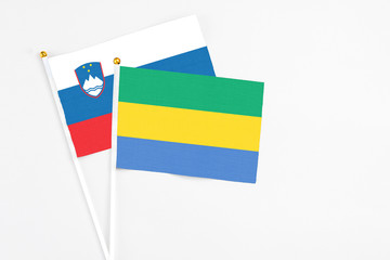 Gabon and Slovenia stick flags on white background. High quality fabric, miniature national flag....