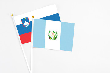 Guatemala and Slovenia stick flags on white background. High quality fabric, miniature national flag. Peaceful global concept.White floor for copy space.