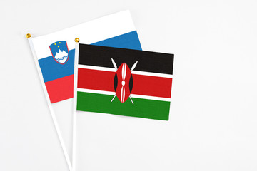 Kenya and Slovenia stick flags on white background. High quality fabric, miniature national flag. Peaceful global concept.White floor for copy space.